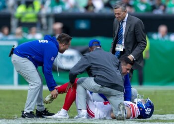 Trainers checking on New York Giants running back Cam Skattebo (44) after he twisted his ankle.