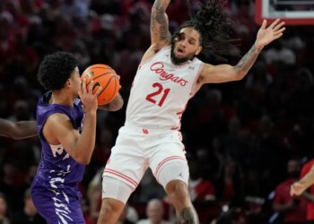 PJ Haggerty looks to pass the ball while Emanuel Sharp defends.