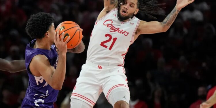 PJ Haggerty looks to pass the ball while Emanuel Sharp defends.