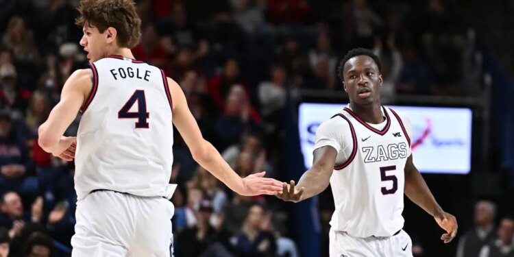 Two basketball players, one wearing jersey number 4 with the name "FOGLE" and the other wearing number 5 with "ZAGS", touch hands during an NCAA basketball game.