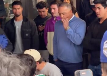 Dave Roberts smoking a cigar while watching a wing-eating contest.