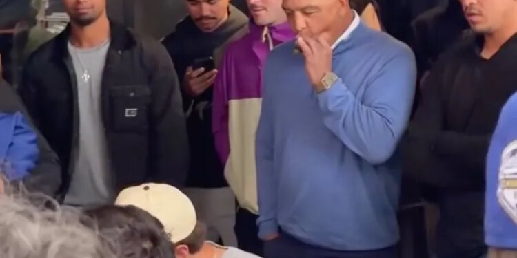 Dave Roberts smoking a cigar while watching a wing-eating contest.