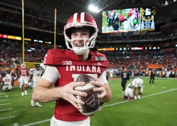 Fernando Mendoza, quarterback for Indiana, smiles while holding a football.