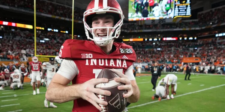 Fernando Mendoza, quarterback for Indiana, smiles while holding a football.
