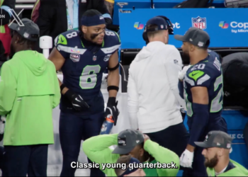 Julian Love, in a Seattle Seahawks uniform, stands on the sidelines.