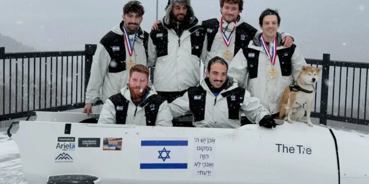 Members of Israel's Winter Olympics bobsleigh team, with Adam “AJ” Edelman (right), posing with their bobsled and a dog.