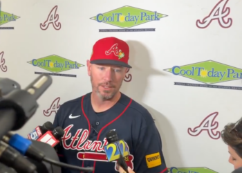 Baseball player Josh Donaldson speaking into multiple microphones.
