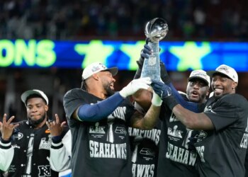Seahawks players hoist Super Bowl trophy.