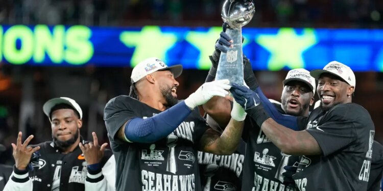 Seahawks players hoist Super Bowl trophy.