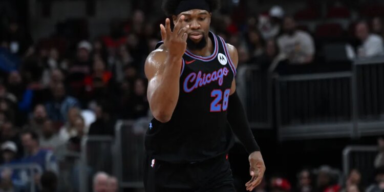 Guerschon Yabusele in a black jersey with "Chicago" and number 28, holding up three fingers after scoring a three-point basket.