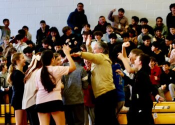 Jimmy Mellor, a Samoset Middle School teacher, celebrates with students after his half-court shot at a pep rally got them out of homework.