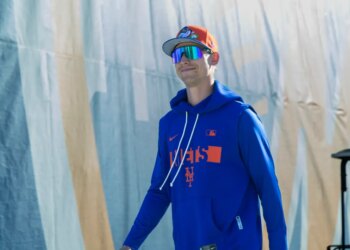 New York Mets pitcher Luke Weaver in a blue hoodie and orange cap.