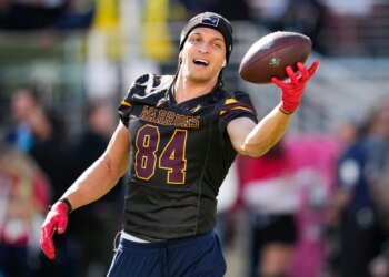 New England Patriots wide receiver Mack Hollins warming up with a football.