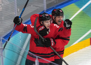 Canada's Nathan MacKinnon (29) celebrates with Sam Reinhart (13) after MacKinnon scored a goal against Finland during the third period of a men's ice hockey semifinal game at the 2026 Winter Olympics in Milan, Italy, Friday, Feb. 20, 2026. (AP Photo/Carolyn Kaster)