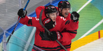Canada's Nathan MacKinnon (29) celebrates with Sam Reinhart (13) after MacKinnon scored a goal against Finland during the third period of a men's ice hockey semifinal game at the 2026 Winter Olympics in Milan, Italy, Friday, Feb. 20, 2026. (AP Photo/Carolyn Kaster)