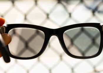 Close up of the second-gen Ray-Ban Meta glasses with fencing in the background