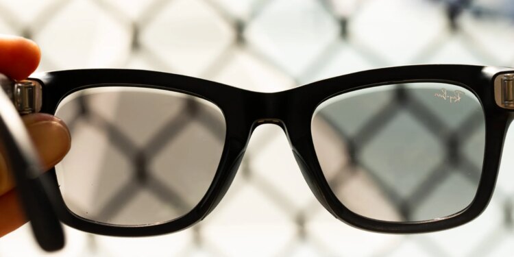 Close up of the second-gen Ray-Ban Meta glasses with fencing in the background
