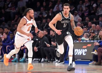 Brooklyn Nets forward Michael Porter Jr. dribbles down the court as New York Knicks guard Jalen Brunson gives chase.