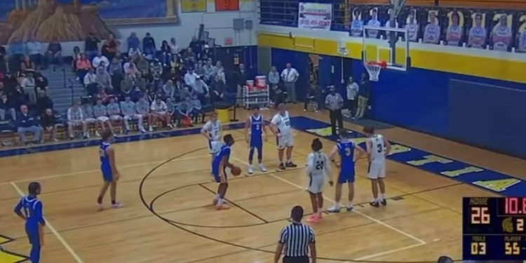 A basketball game in progress with players on the court and spectators in the stands.