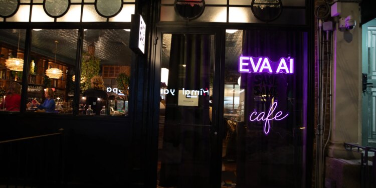 Outside view of a wine bar where you can see people through the window. In neon purple lights is the word EVA AI cafe.