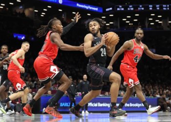 Brooklyn Nets' Cam Thomas #24 looks for a pass as Chicago Bulls' Ayo Dosunmu #11 defends him.