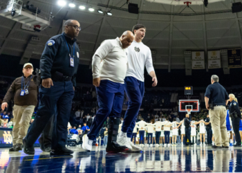 Notre Dame head coach Micah Shrewsberry is helped off the court while wearing a boot.