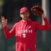 Trea Turner of the Philadelphia Phillies in a red Phillies hoodie and hat holding a baseball glove.