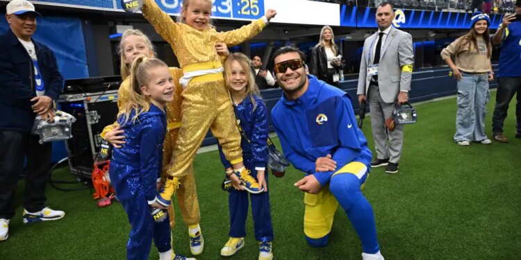 Los Angeles Rams wide receiver Puka Nacua (12) poses for a picture with quarterback Matthew Stafford’s daughters.