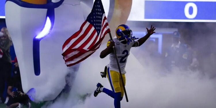 Robert Woods running onto the field carrying an American flag.
