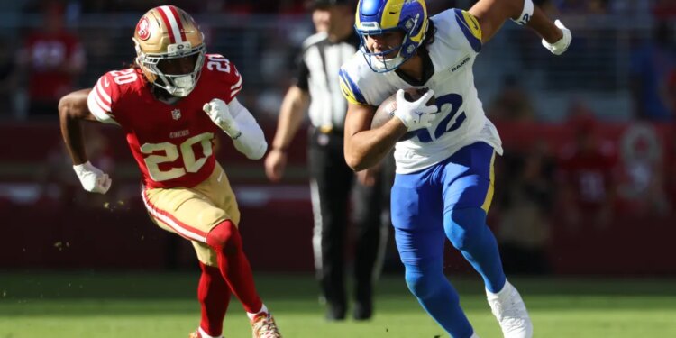 Los Angeles Rams wide receiver Puka Nacua (12) running while San Francisco 49ers cornerback Upton Stout (20) chases him from behind.