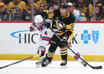 Pittsburgh Penguins Egor Chinakhov (59) moves the puck against New York Rangers Braden Schneider (4).