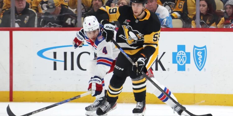 Pittsburgh Penguins Egor Chinakhov (59) moves the puck against New York Rangers Braden Schneider (4).