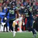 Seattle Seahawks players Leonard Williams (99) and Derick Hall (58) celebrating after sacking the San Francisco 49ers quarterback.