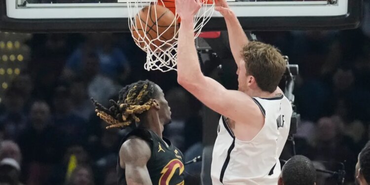 Brooklyn Nets forward Danny Wolf (2) dunks next to Cleveland Cavaliers guard Keon Ellis, left, in the first half of an NBA basketball game in Cleveland, Thursday, Feb. 19, 2026.