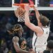 Brooklyn Nets forward Danny Wolf (2) dunks next to Cleveland Cavaliers guard Keon Ellis, left, in the first half of an NBA basketball game in Cleveland, Thursday, Feb. 19, 2026.