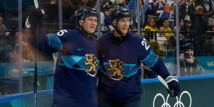 Anton Lundell and Eetu Luostarinen of Finland celebrating a goal during a men's ice hockey game.