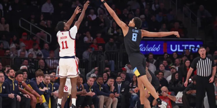 St. John's Red Storm guard Ian Jackson #11 shooting over Marquette Golden Eagles forward Josh Clark #8.