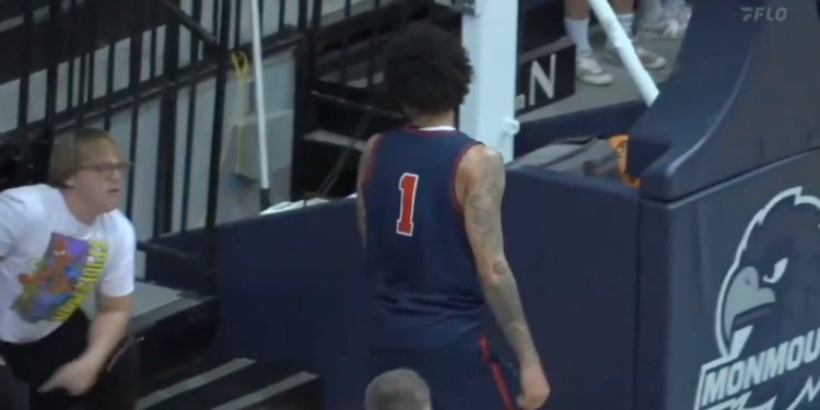 A basketball player in a number 1 jersey stands near the Monmouth logo on a court, while a fan in a white Spider-Man shirt looks on.