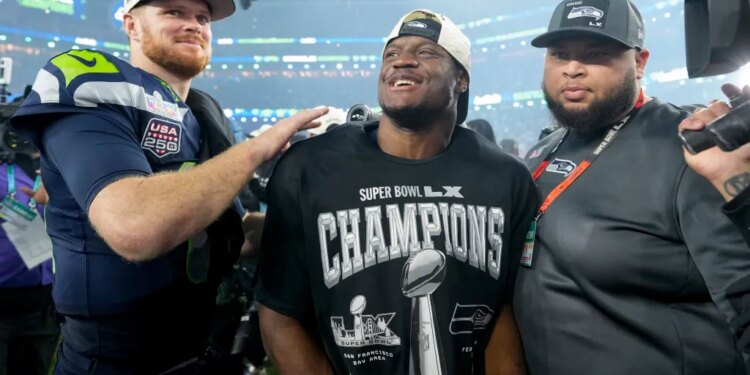 Sam Darnold with his arm around Kenneth Walker III, who is wearing a Super Bowl LX Champions shirt, celebrating their victory.