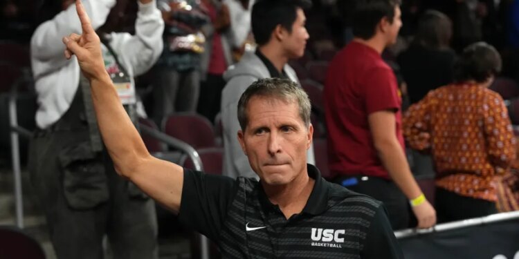 Southern California Trojans head coach Eric Musselman holds up a "Fight On" sign after a victory.