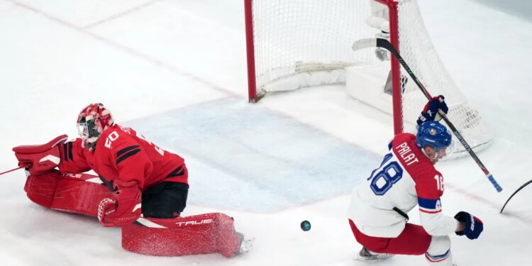 Czechia's Ondrej Palat (18) scores a goal against Canada goalkeeper Jordan Binnington (50) during the third period of a men's ice hockey quarterfinal on Feb. 18, 2026, at the Winter Olympics.