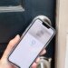 A hand holding an iPhone up to a door. On the phone screen is a picture of a keycard with the Apple Home logo, and the words “My Home” above it. Below it is a blue checkmark in a circle and the word “Done.”