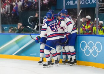 Jack Hughes (86) of the United States celebrates with teammates after scoring a goal during the second period against Slovakia in a men's ice hockey semifinal during the Milano Cortina 2026 Olympic Winter Games at Milano Santagiulia Ice Hockey Arena.