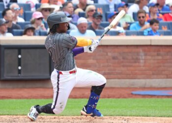Luisangel Acuña hitting an RBI go-ahead double during a New York Mets game.