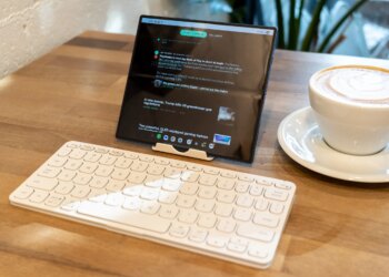Folding phone propped up on a table with a travel keyboard.