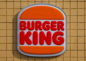 Burger King sign featuring red bold letters for "BURGER KING" between two orange bun shapes.