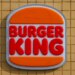 Burger King sign featuring red bold letters for "BURGER KING" between two orange bun shapes.