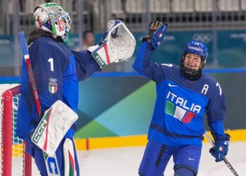 Italian ice hockey players Gabriella Frances Durante and Laura Fortino celebrate a goal during a game.