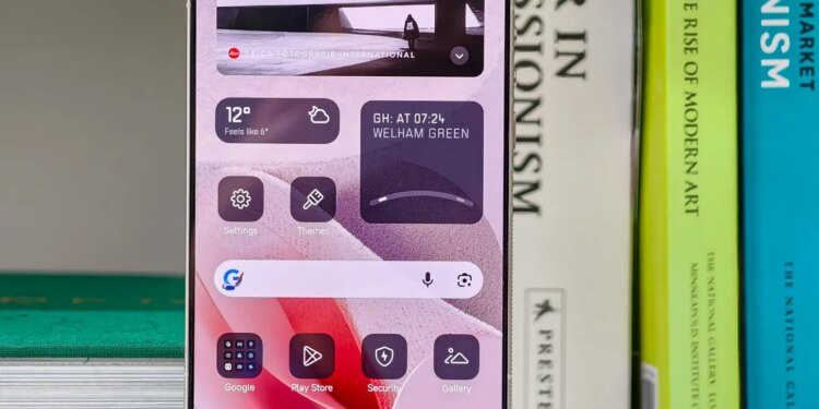 Photo of the Xiaomi Leica Leitzphone on a bookshelf, showing the home screen with monochrome widgets