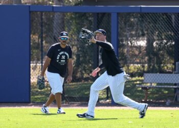 New York Yankees right fielder Aaron Judge catches a ball in front of center fielder Trent Grisham during spring training.